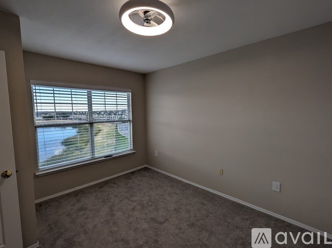 A room with a carpeted floor and a window overlooking a body of water.