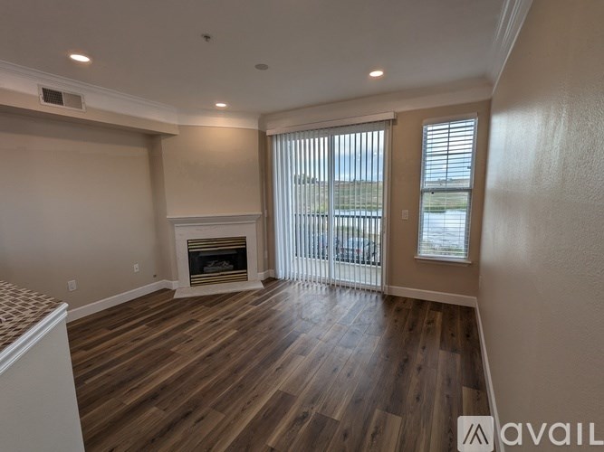 A spacious living room with a fireplace and wooden flooring.