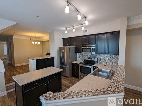 A kitchen with black cabinets and a tiled backsplash.
