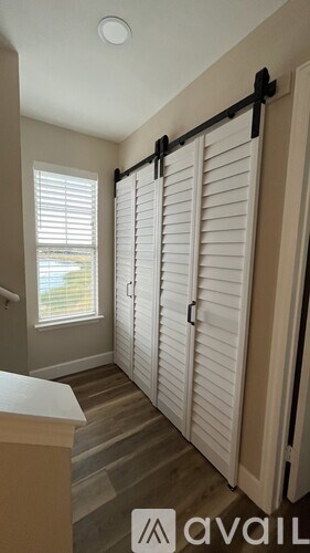 A white shuttered door in a room with a window.