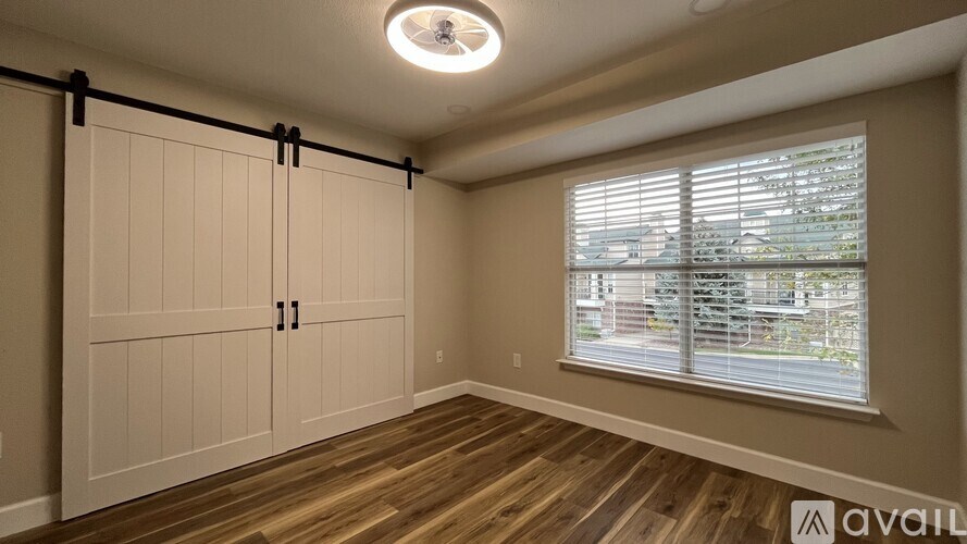 A room with a window and a wooden floor.
