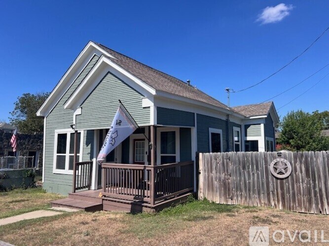 A small house with a porch and a flag on it.
