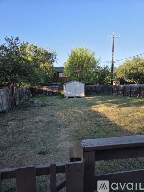 A backyard with a wooden fence and a shed.