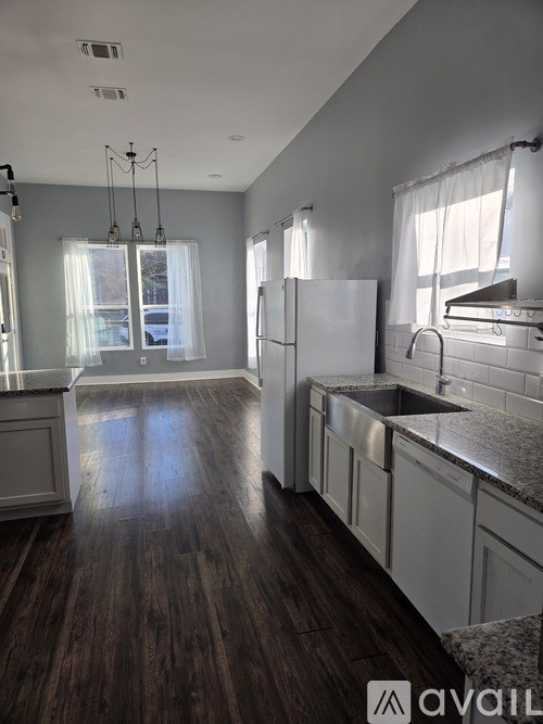 A blue chair is on a wooden deck with a table and a cat.