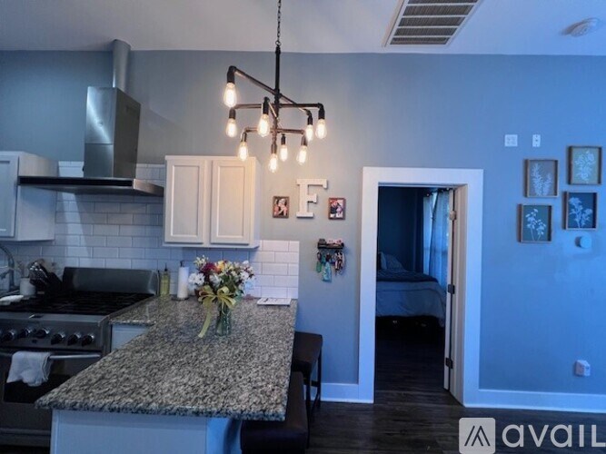 A kitchen with granite countertops and a stainless steel range hood.