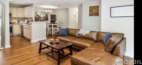 A living room with a brown leather couch and a wooden coffee table.