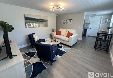 A living room with a white couch and a blue chair.