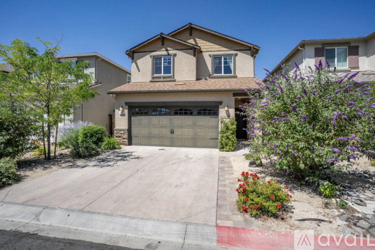 A house with a garage and a driveway in front of it.