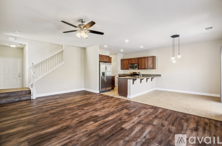 A spacious room with wooden flooring and a ceiling fan.