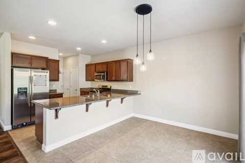A kitchen with a refrigerator, cabinets, and a countertop.