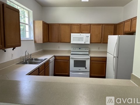 A kitchen with wooden cabinets and a white fridge.