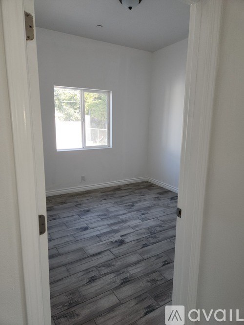 A room with a window and wooden flooring.