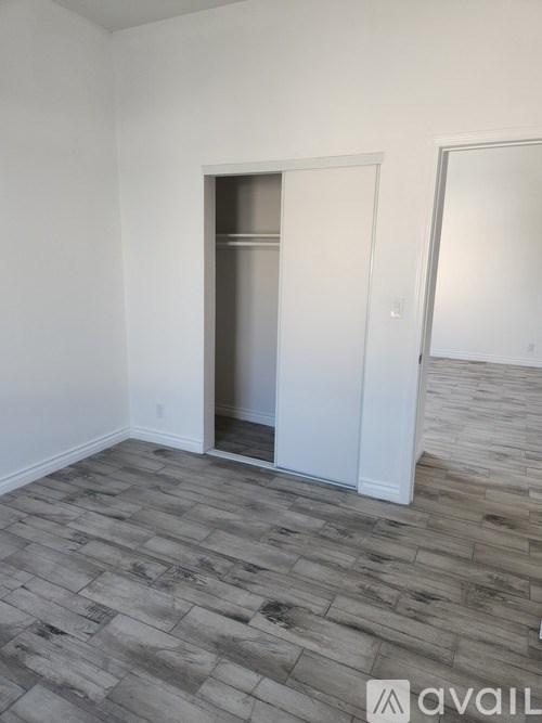 A room with a wooden floor and a white door.