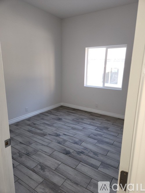 A room with a window and a wooden floor.