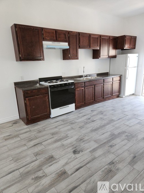 A kitchen with wooden cabinets and a black stove top oven.
