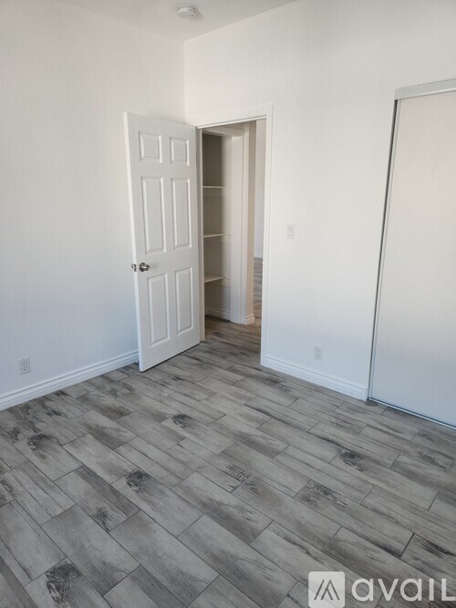 A room with a door and a wooden floor.