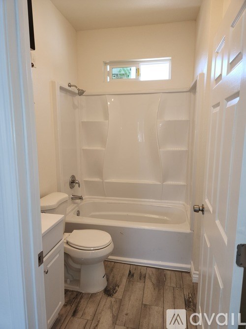 A white bathroom with a toilet, sink, and bathtub.