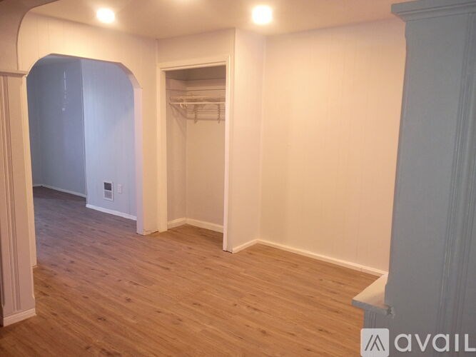 A room with wooden flooring and white walls.