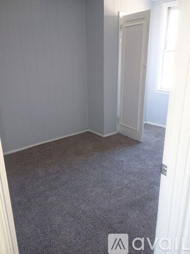 A room with a carpeted floor and a door.
