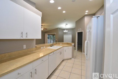 A kitchen with white cabinets and a beige countertop.
