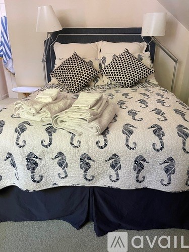 A bed with a black headboard and a white comforter with elephant patterns.