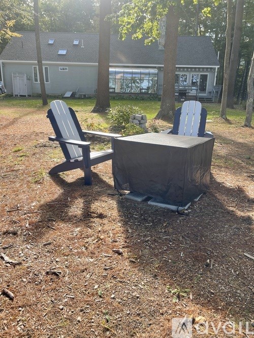 Two chairs and a table are set up on a dirt ground.