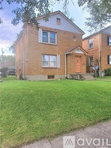 A brick house with a green lawn in front.