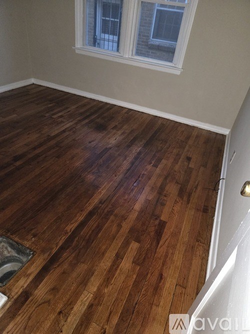 A room with wooden flooring and a window.