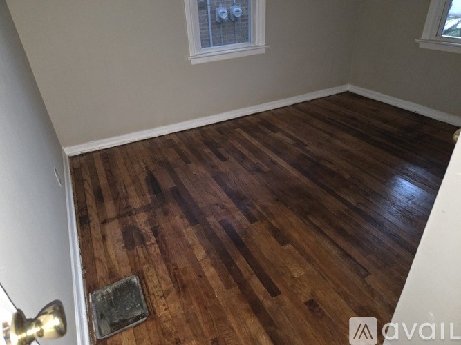 A room with wooden flooring and a white door.