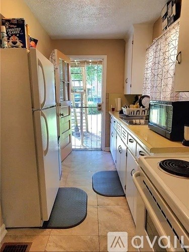 A kitchen with a white refrigerator and white stove.