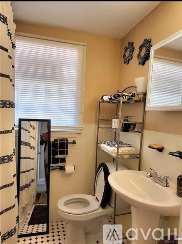 A bathroom with a toilet, sink, and a mirror.