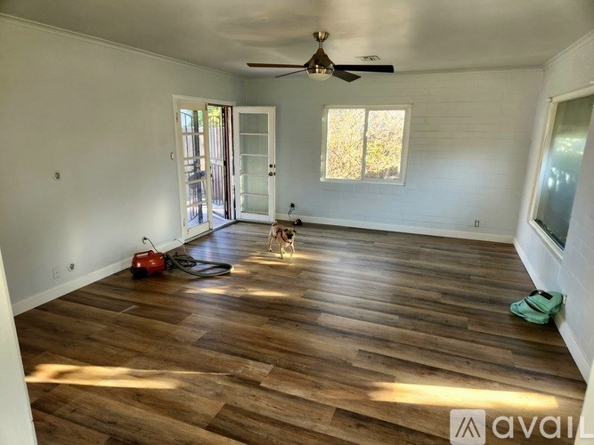 A room with wooden flooring and a ceiling fan.