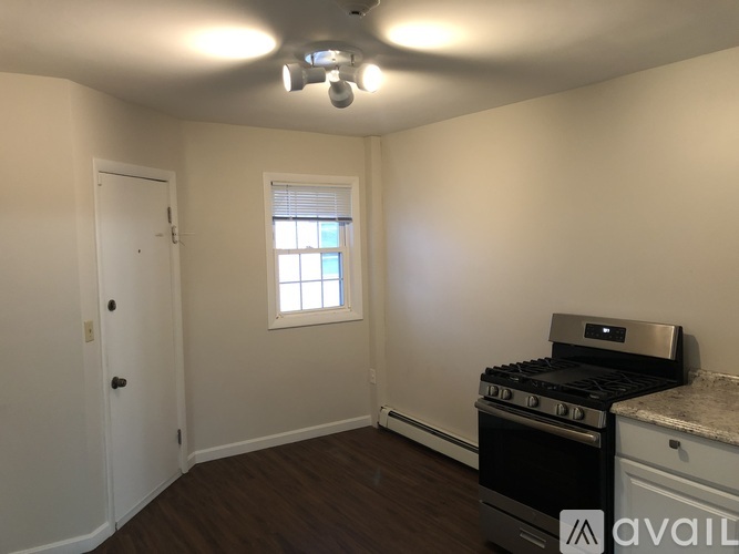 A kitchen with a stove and oven, a window, and a door.