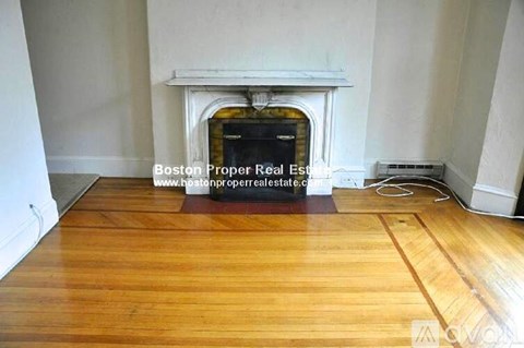 A room with a fireplace and wooden floors.