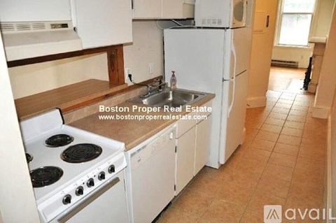 A kitchen with white appliances and a wooden countertop.