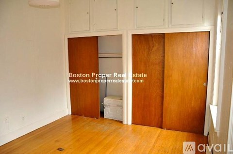 A room with wooden floors and cabinets, and a website address is visible.