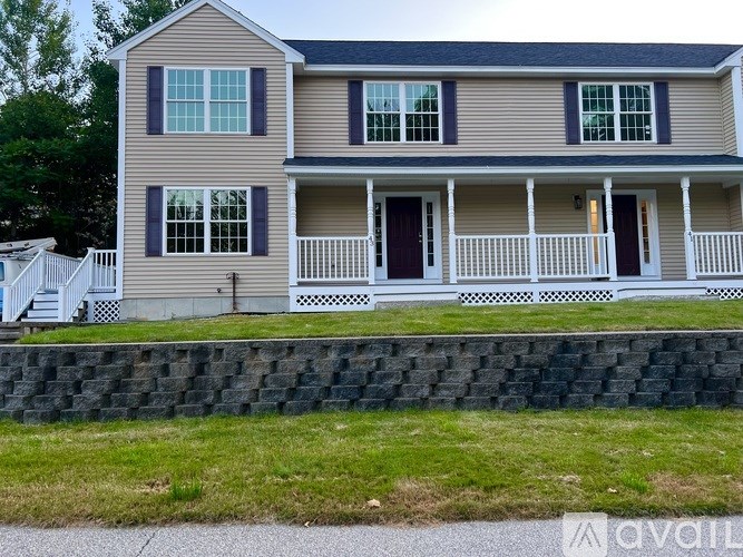 A two-story house with a front porch and a white picket fence.