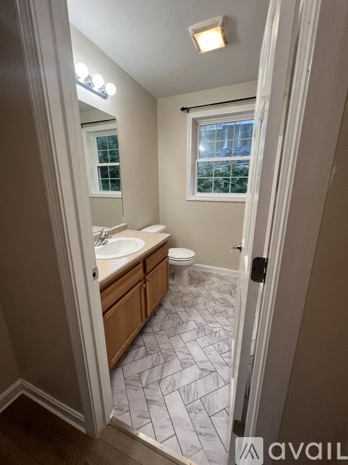 A bathroom with a sink, toilet and a window.
