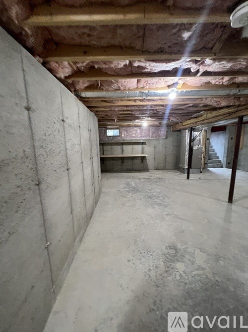 A room with concrete walls and ceiling under construction.