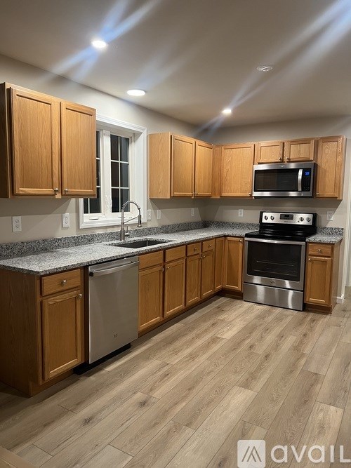 A kitchen with wooden cabinets and a granite countertop.