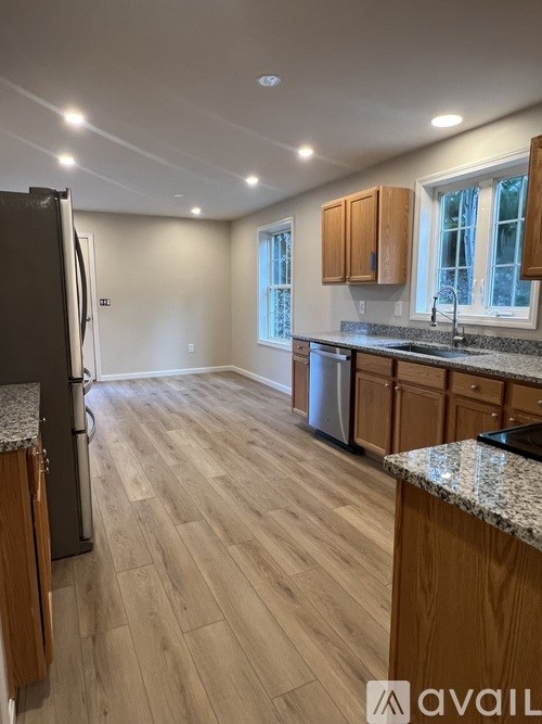 A kitchen with wooden cabinets and a granite countertop.