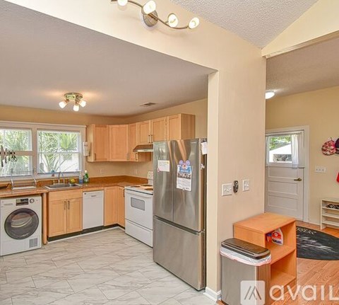 A kitchen with a refrigerator and a washing machine.