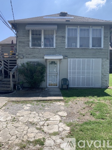 A house with a grey facade and a white fence.