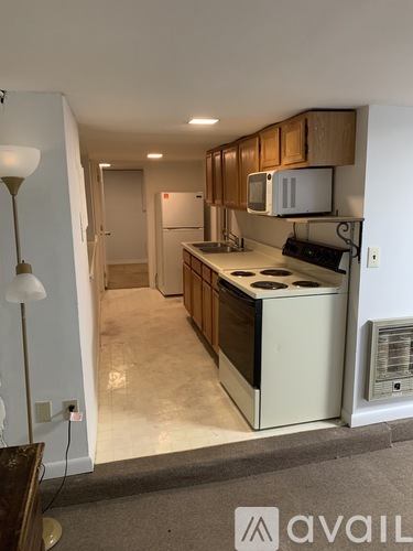 A kitchen with wooden cabinets and a white fridge.