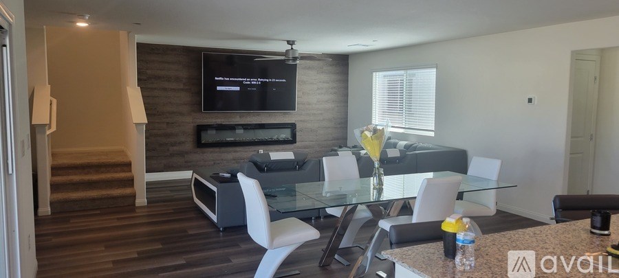 A modern living room with a glass dining table and chairs.
