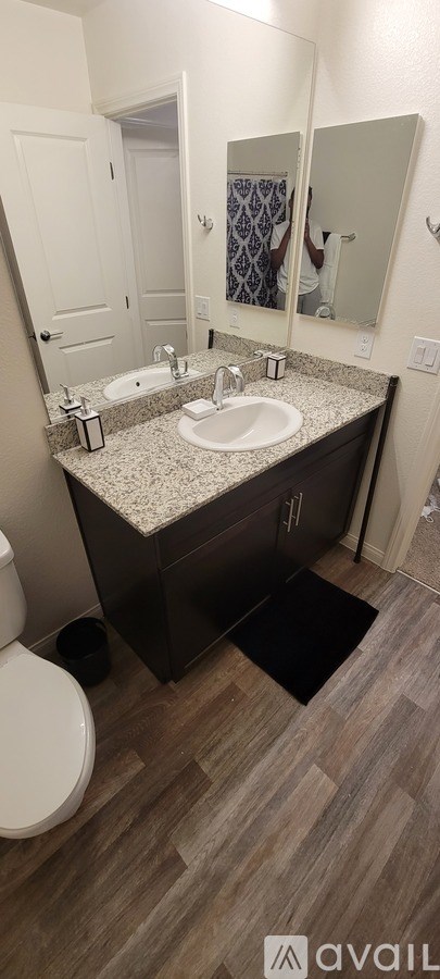 A bathroom with a sink, mirror, and toilet.