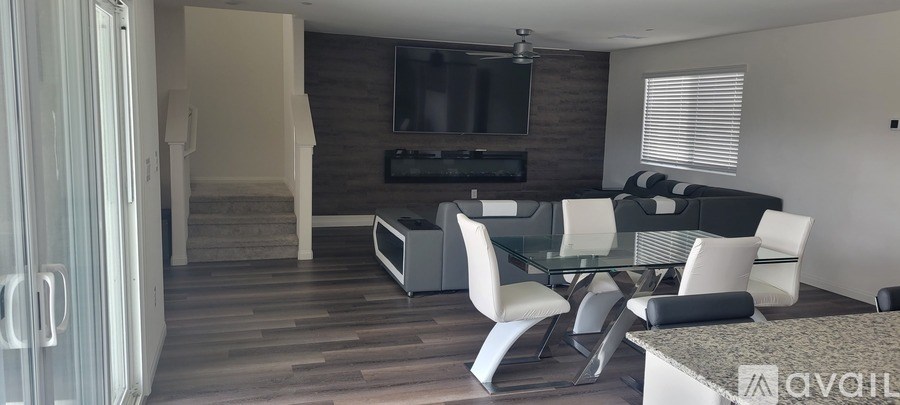 A modern living room with a glass table and white chairs.