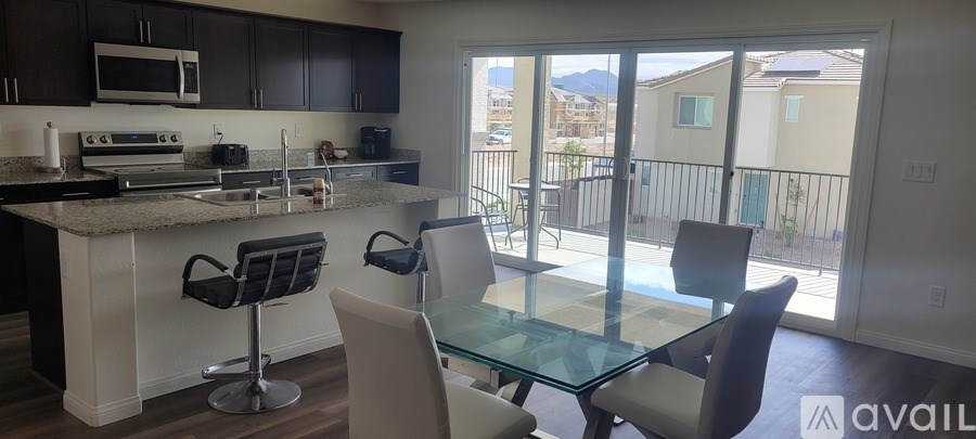 A kitchen with a bar stool and a glass table.