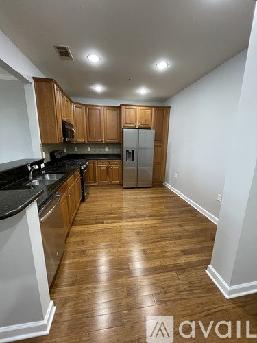 A kitchen with wooden cabinets and a refrigerator.