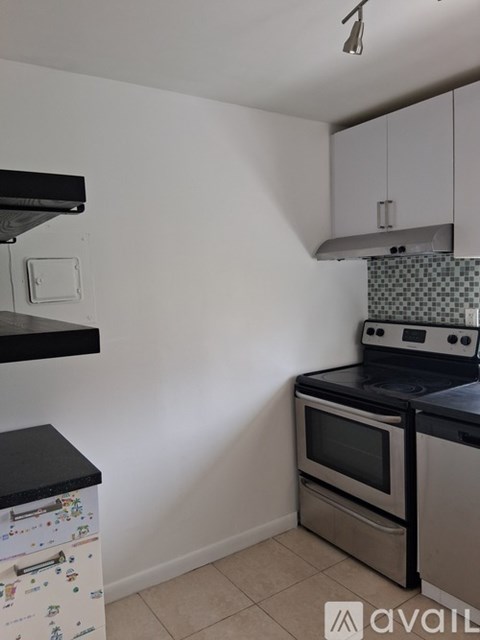 A kitchen with a black countertop and a stove top oven.